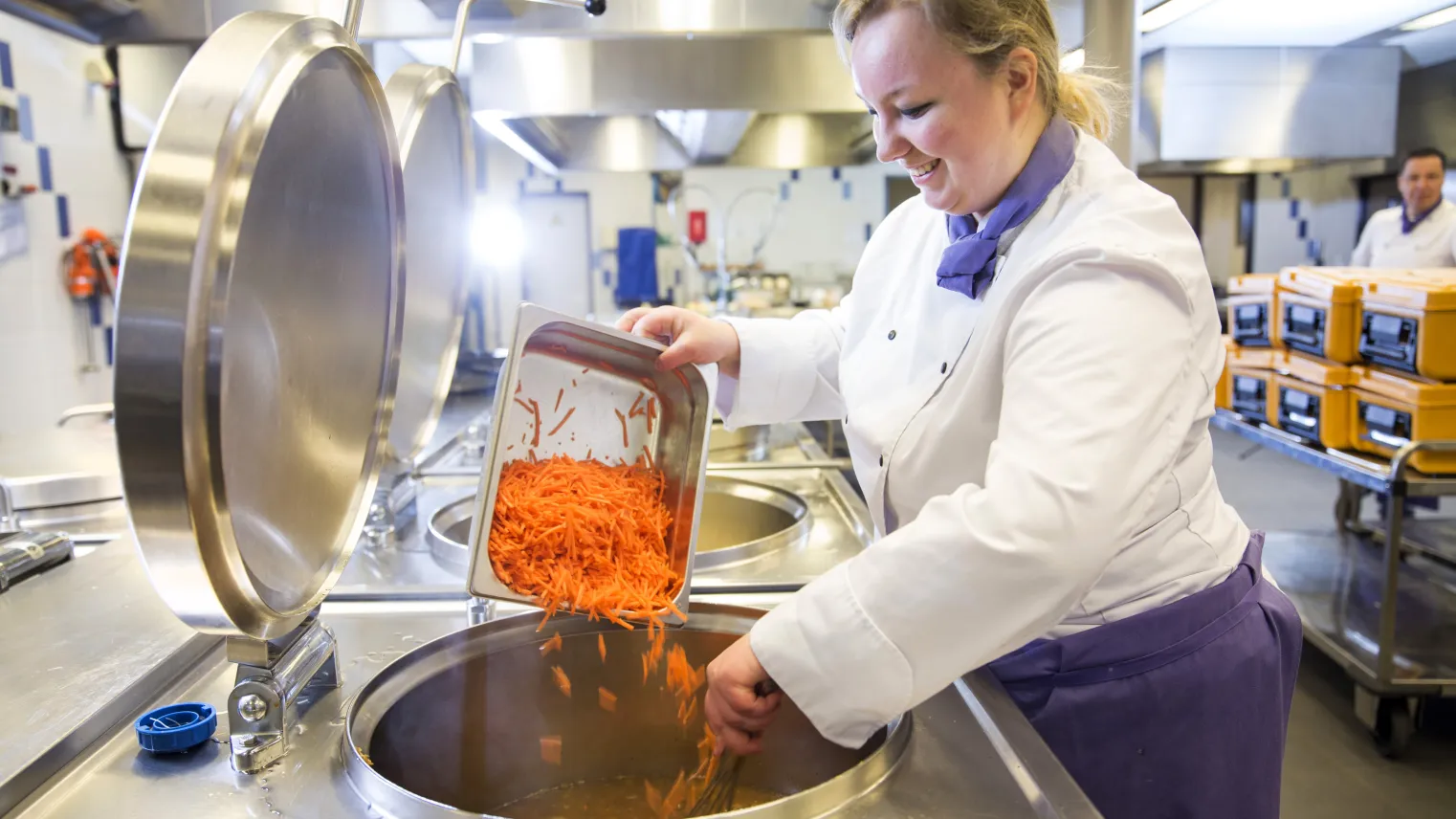 Een kok is aan het koken in de kombuis.