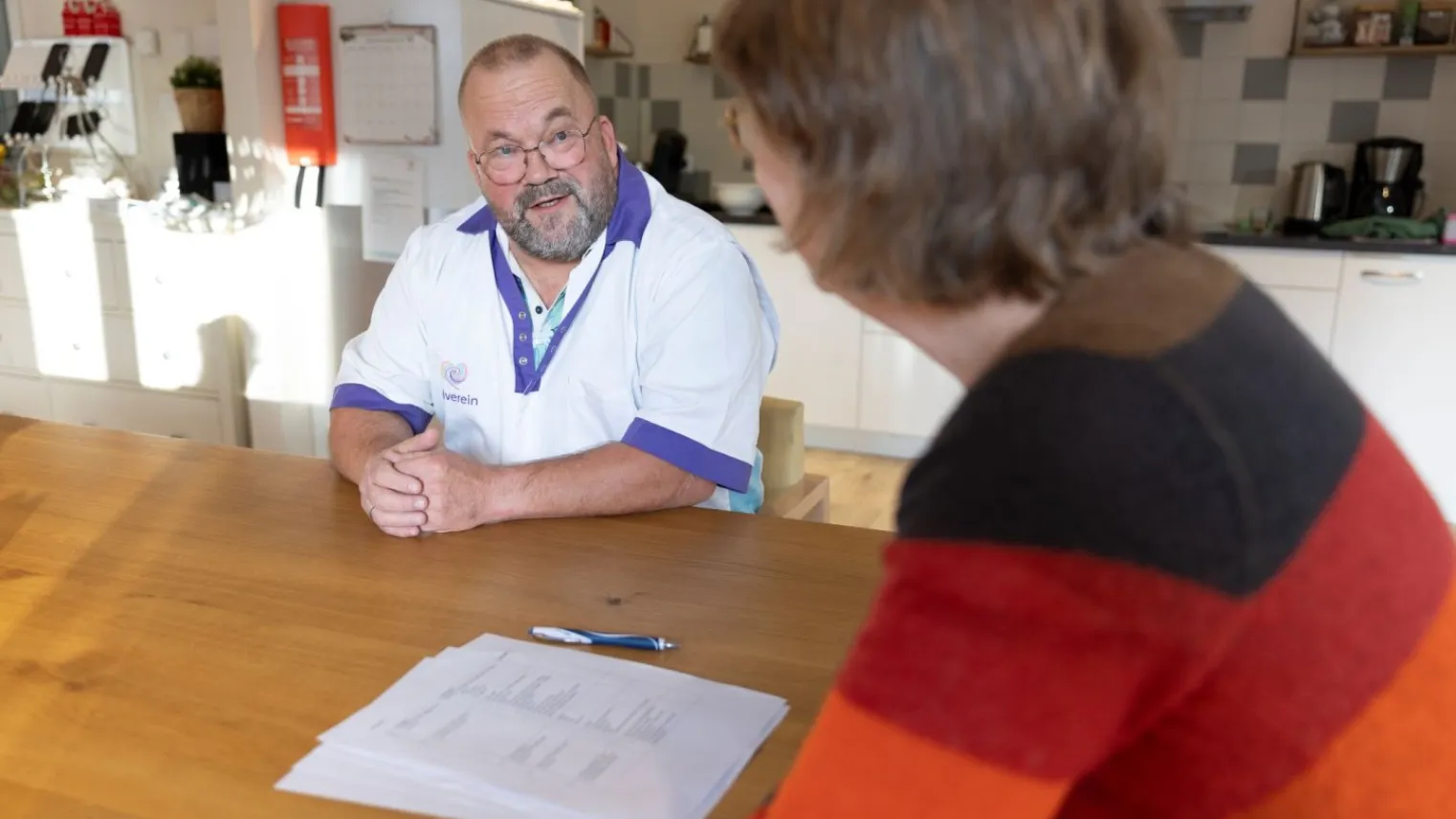 Praktijkopleider voert beoordelingsgesprek met student aan tafel. 