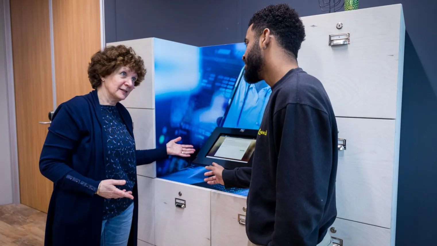 Docent geeft deelnemer van de training smart technology uitleg over machine. 