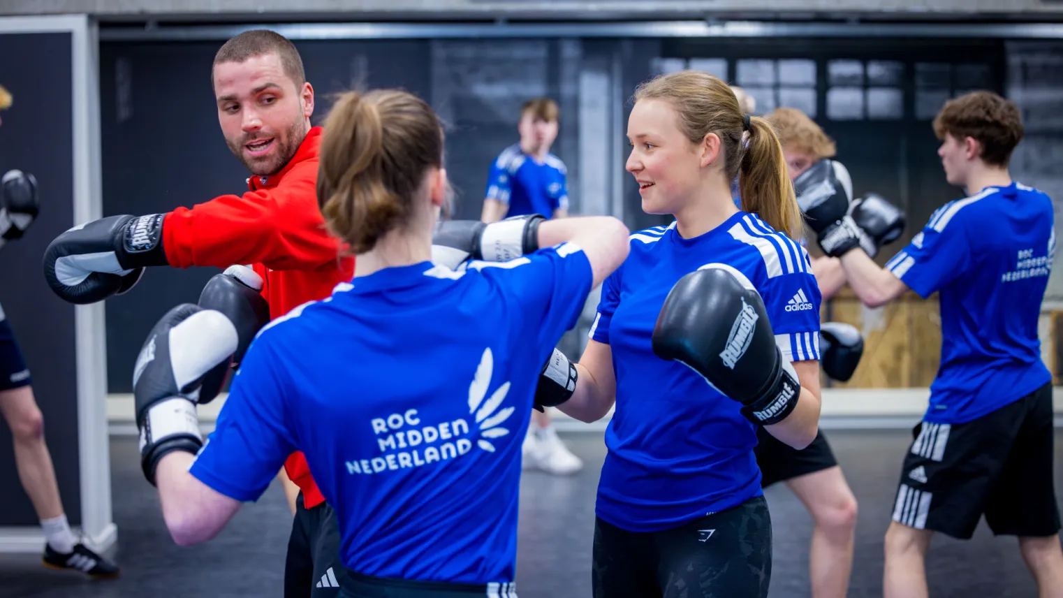 Twee meisjes in sportieve outfits trainen in een sportschool. Ze zijn klaar voor een intensieve bokssessie.