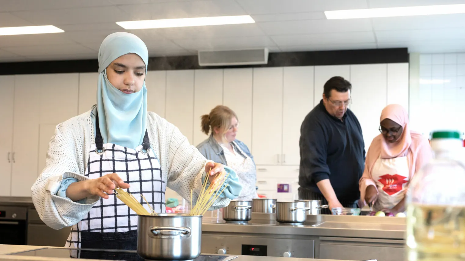 Student Dienstverlener Helpende Zorg & Welzijn maakt eten klaar in een praktijklokaal