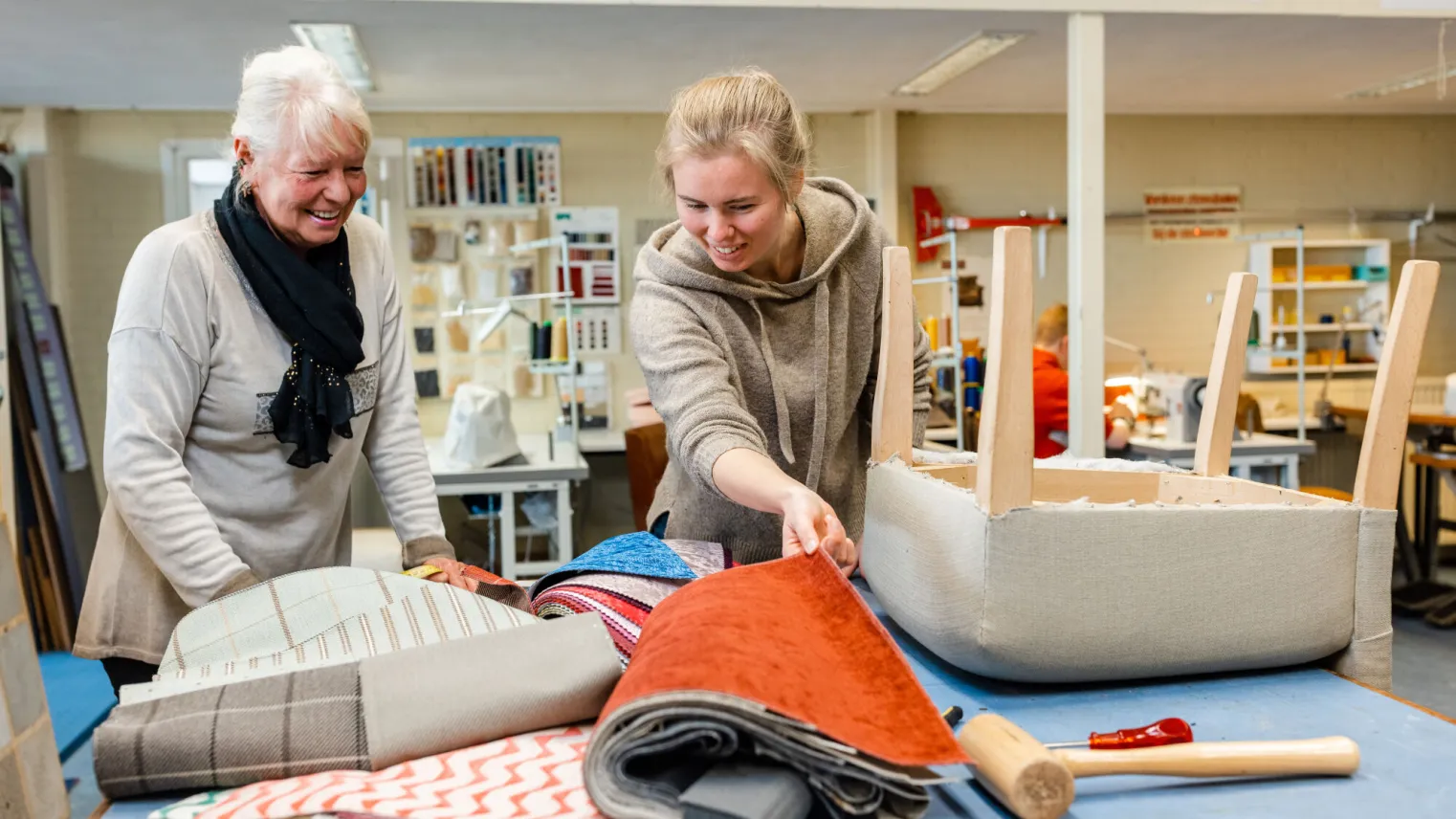 Student en docent kiezen samen een geschikte stof voor een meubel uit 