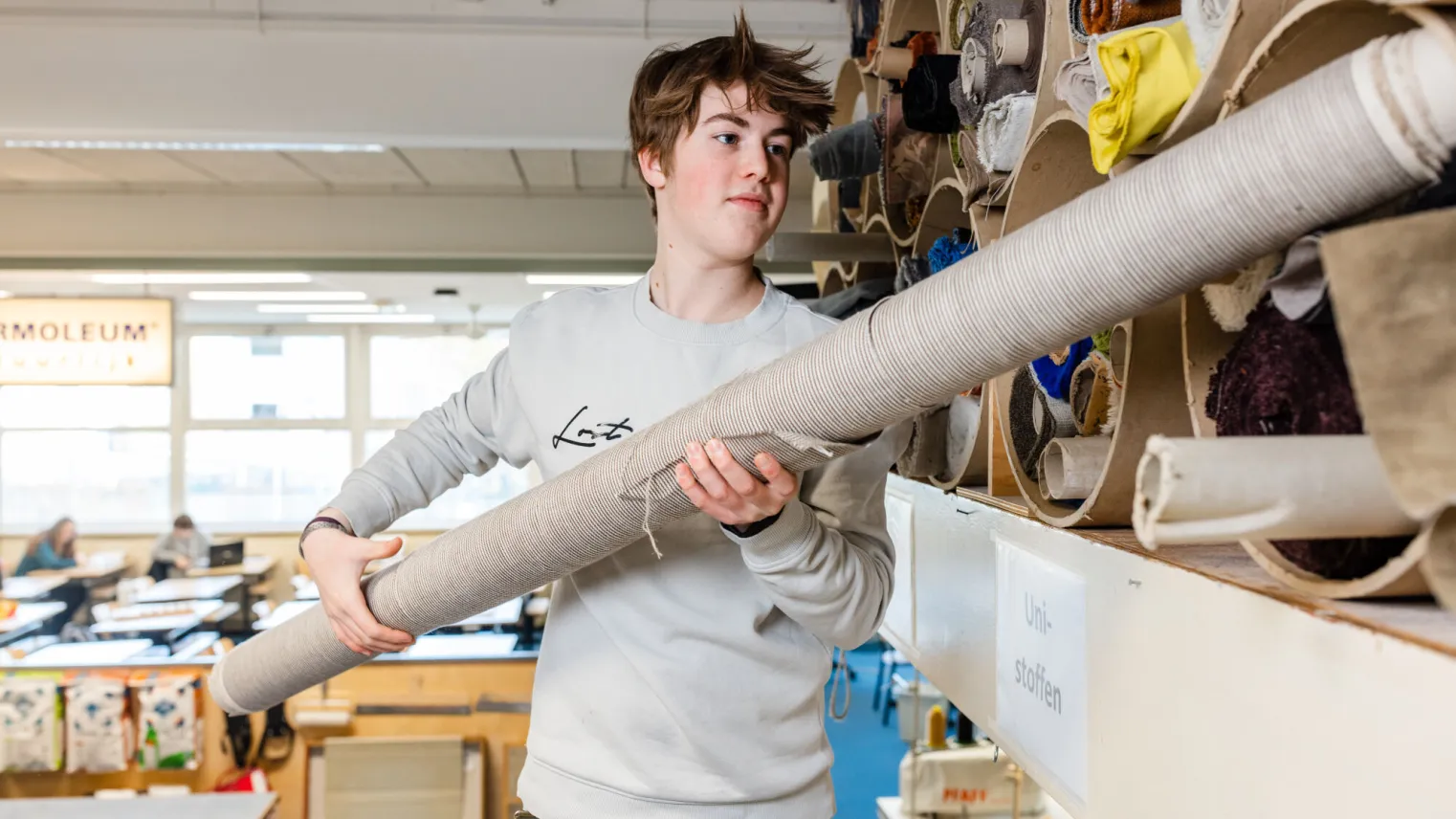 student meubelstofferen pakt rol stof