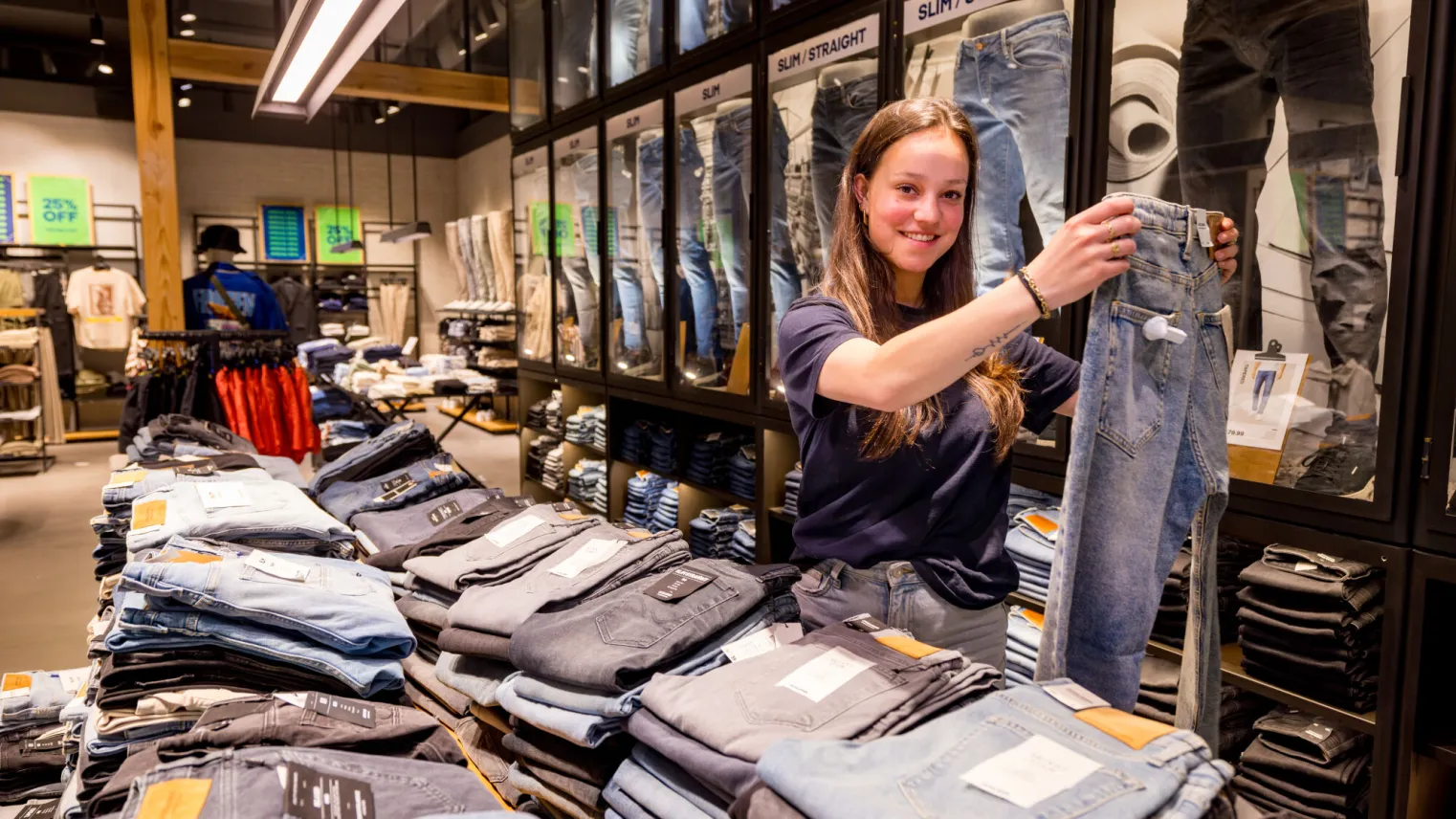 Student Retail vouwt jeans in winkel