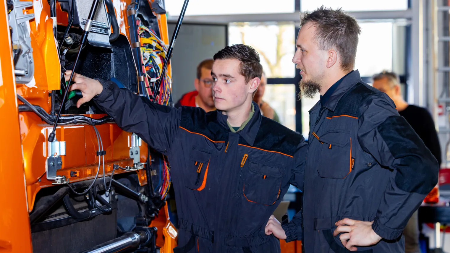 Studenten Technisch Specialist Bedrijfsauto’s werken samen in werkkleding op school