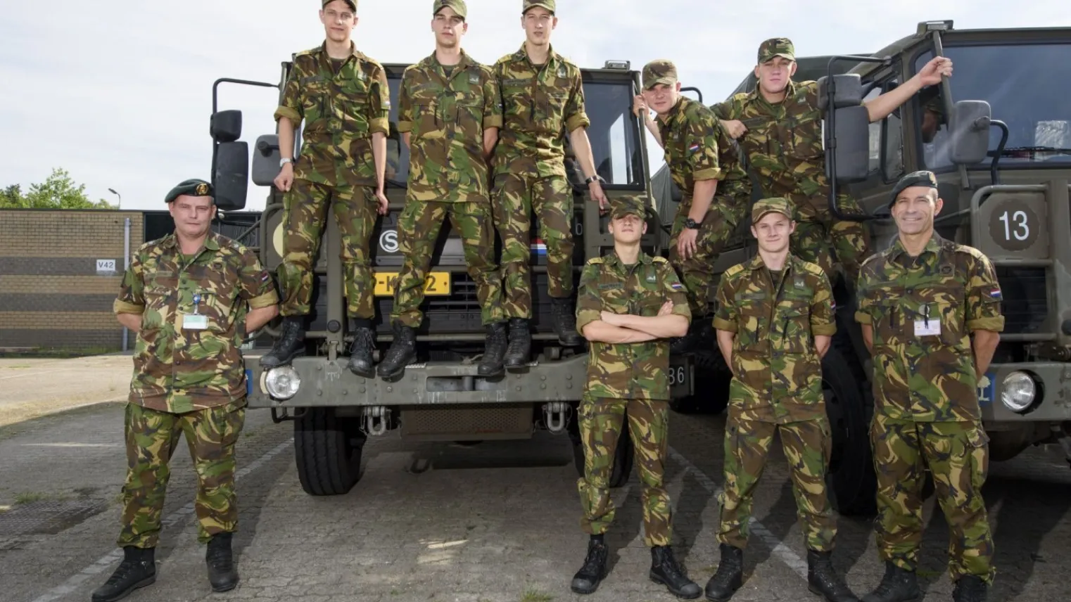 Studenten VEVA Bouw staan bij militaire voertuigen 