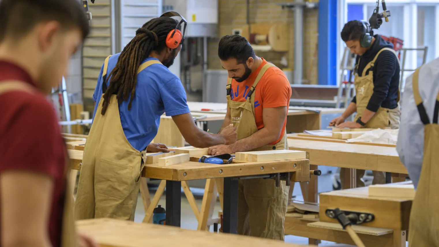 Studenten werken samen in de werkplaats aan houtprojecten