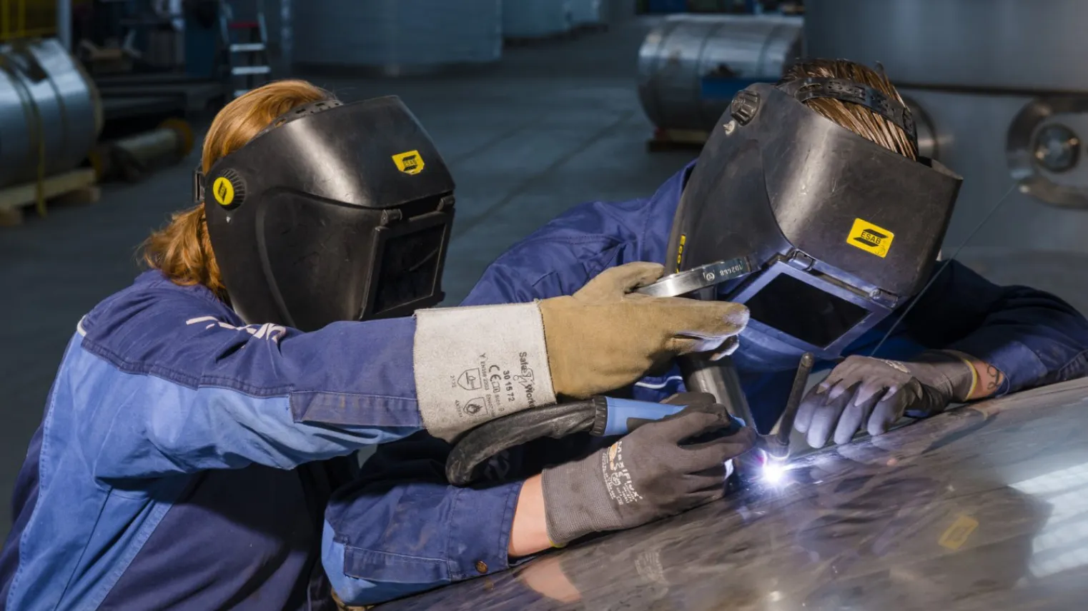 Twee studenten in de werkplaats zijn bezig met plaatwerk 