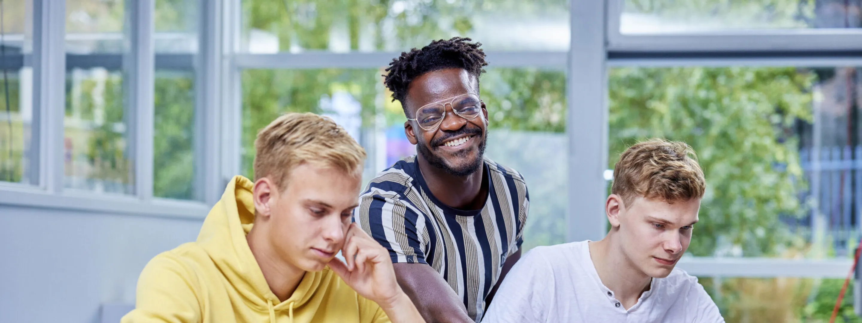 Drie studenten aan het werk achter de laptop