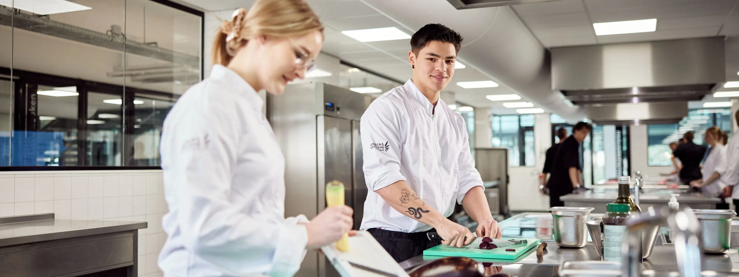 Studentleerling koks bereiden een menu in de keuken bij Horeca college