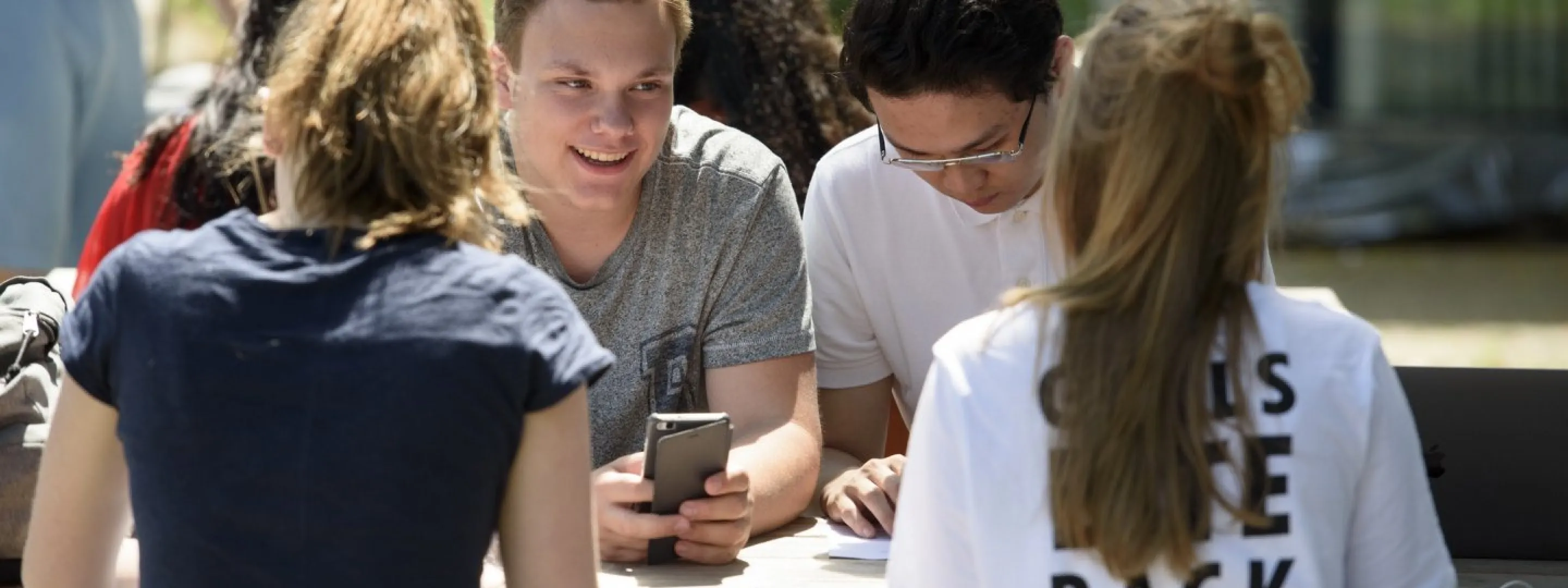 Meerdere studenten houden pauze aan een tafel