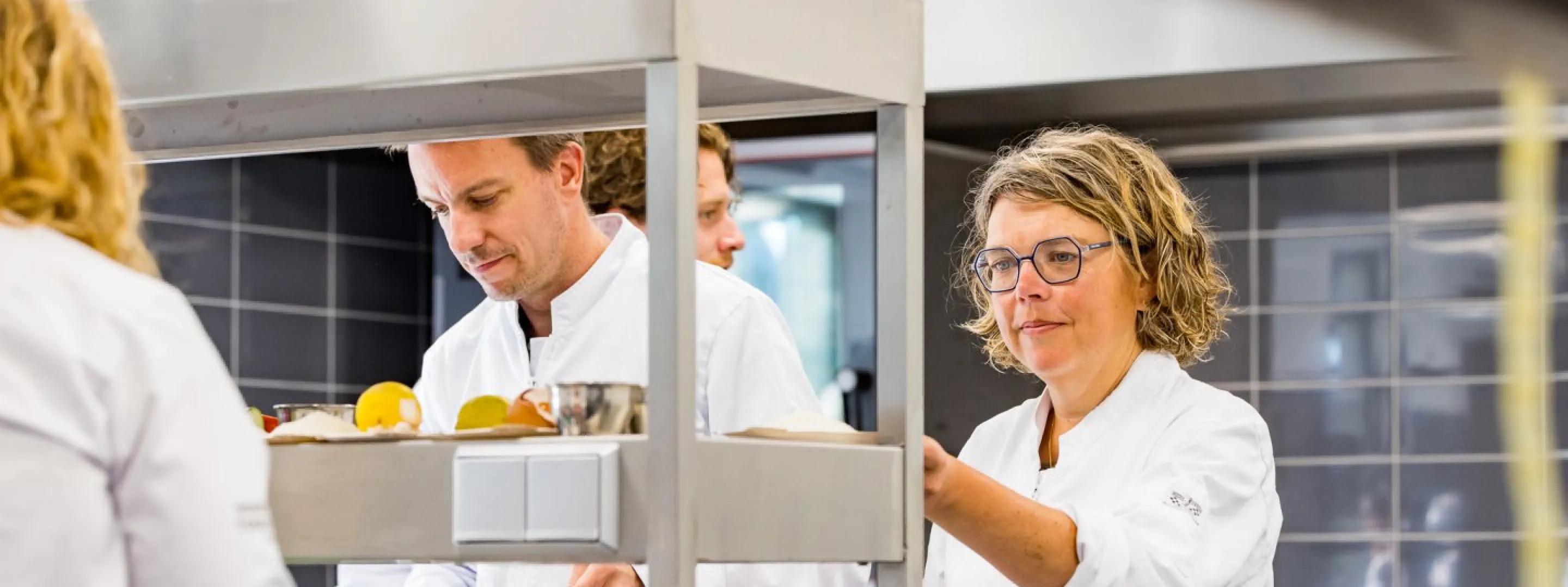 Deelnemers koksopleiding aan het werk in de keuken