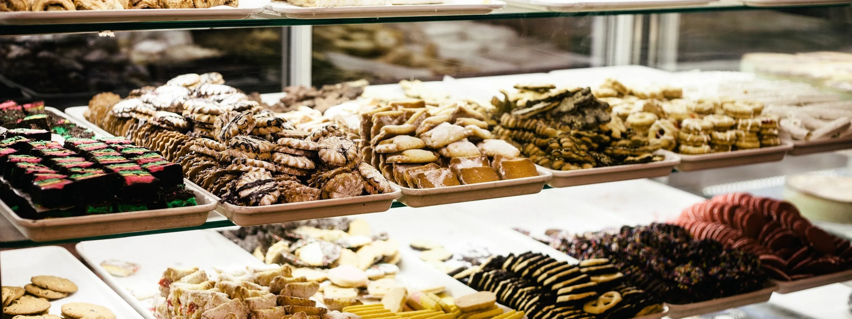 Een vitrinekast vol met verschillende soorten koekjes, perfect voor elke zoetekauw.