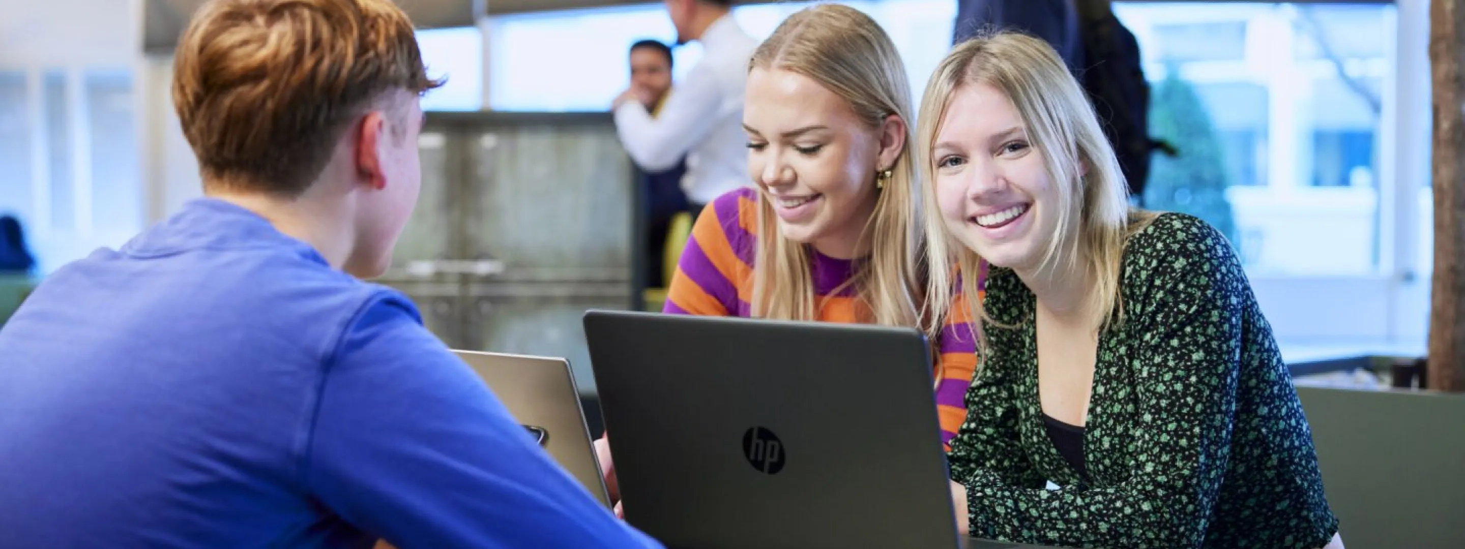 Studenten achter laptop in de kantine