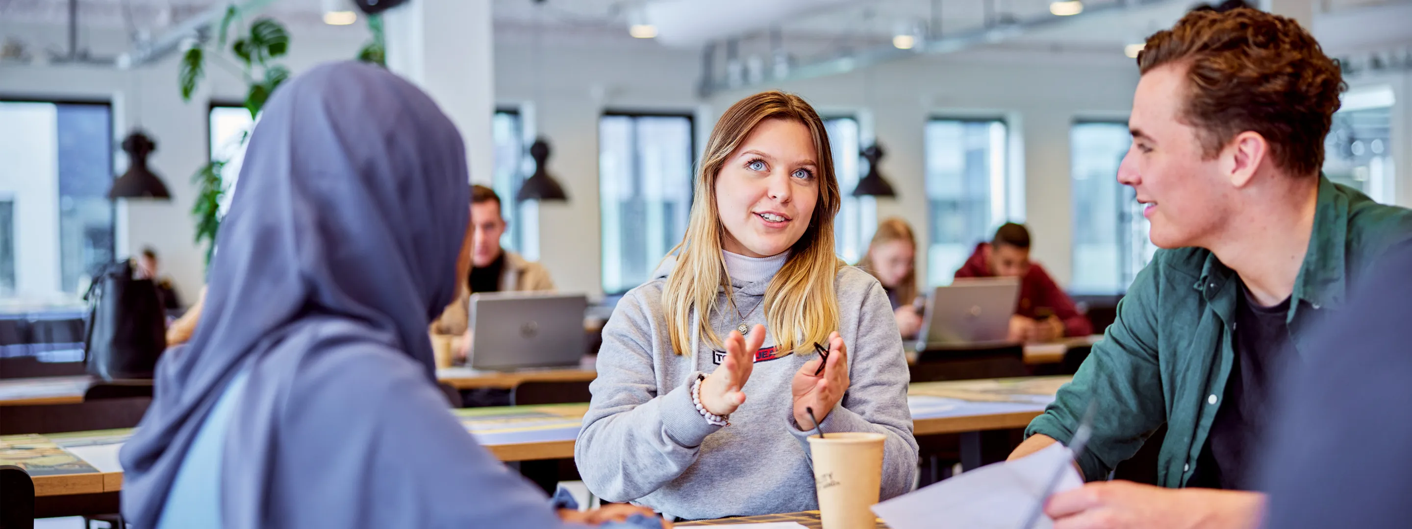 studenten in gesprek met elkaar aan tafel in gemeenschappelijke ruimte