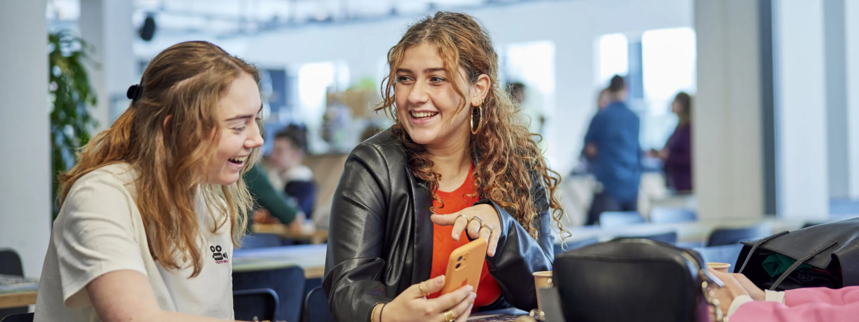 Twee studenten in kantine met elkaar in gesprek